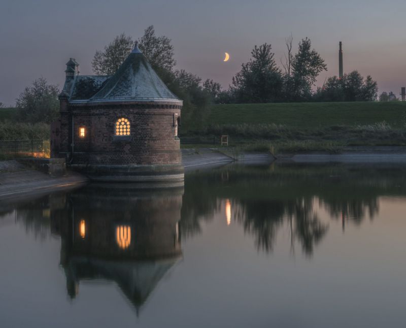 Blick auf das beleuchtete Schieberhäuschen mit Mond im Hintergrund